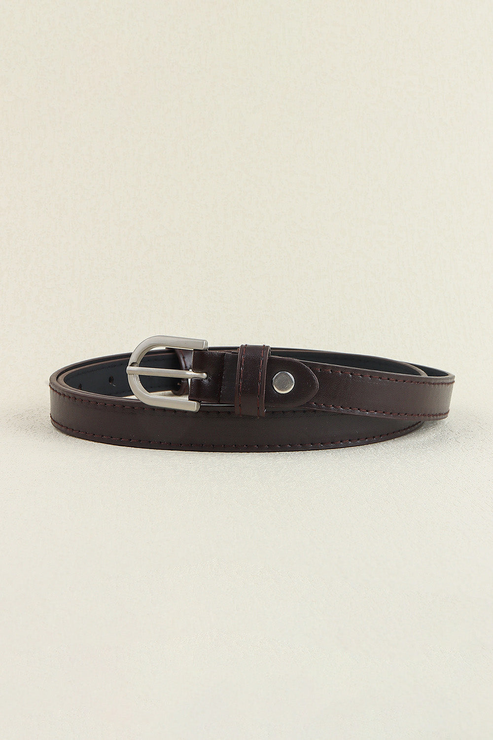 Slimline chocolate leatherette belt with silver buckle and tonal stitching.