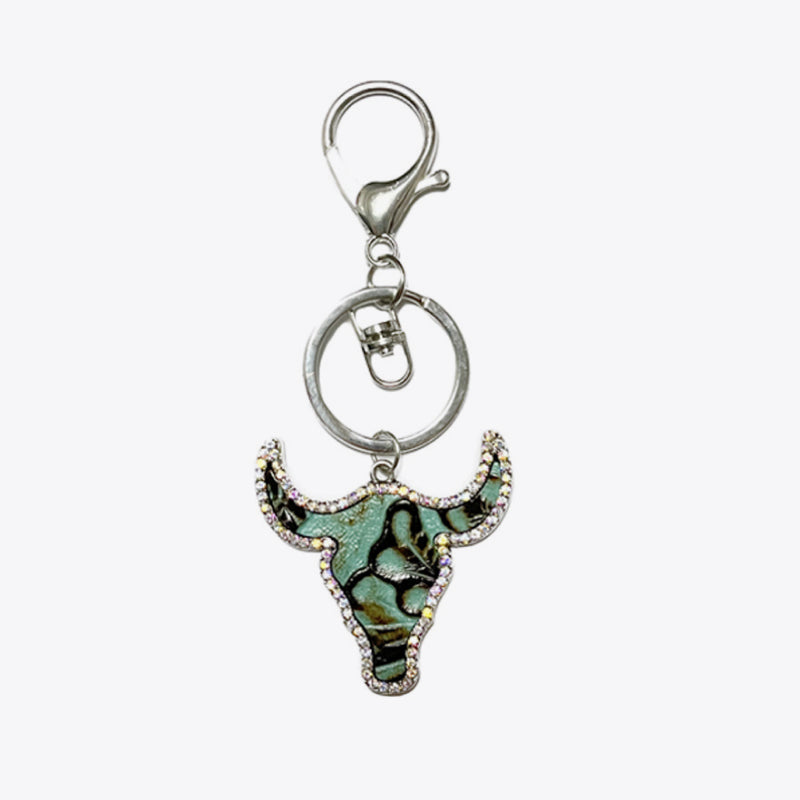 Textured bull head keyring with crystals and a turquoise-like pattern.