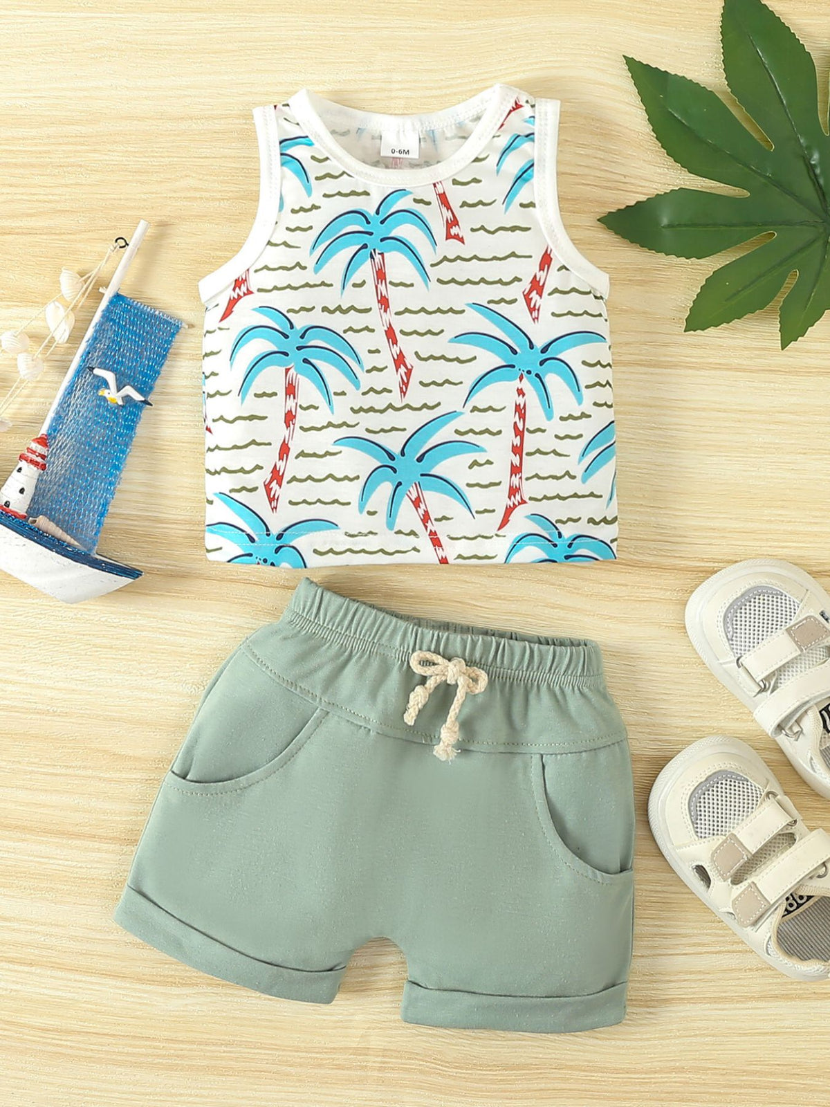 Baby tank top and shorts set in light green with tropical palm print on top.