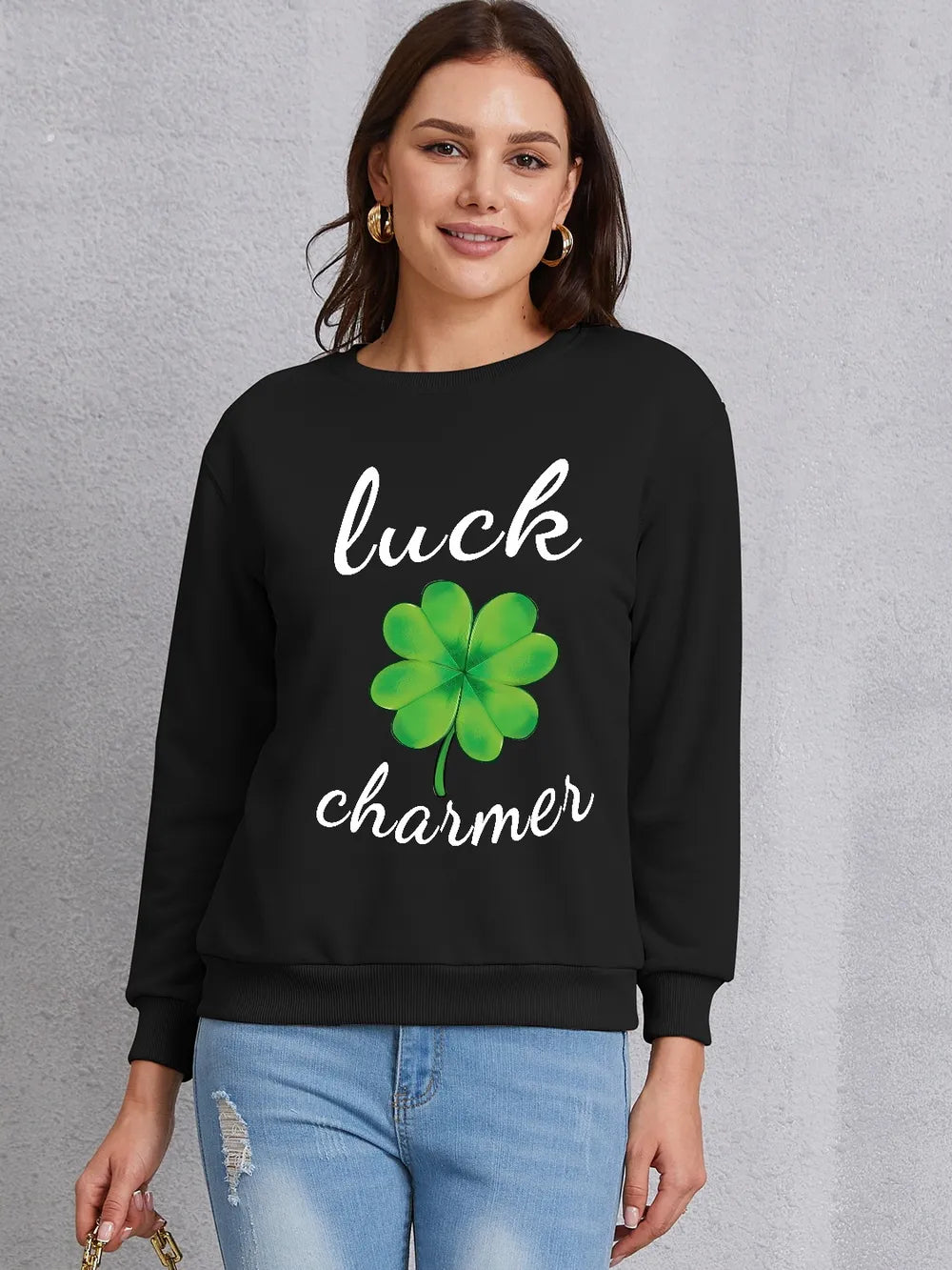 Black graphic sweatshirt with a four-leaf clover and "luck charmer" text.