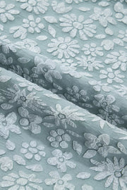 Light blue polyester shirt with white embroidered floral pattern and puff sleeve detail.