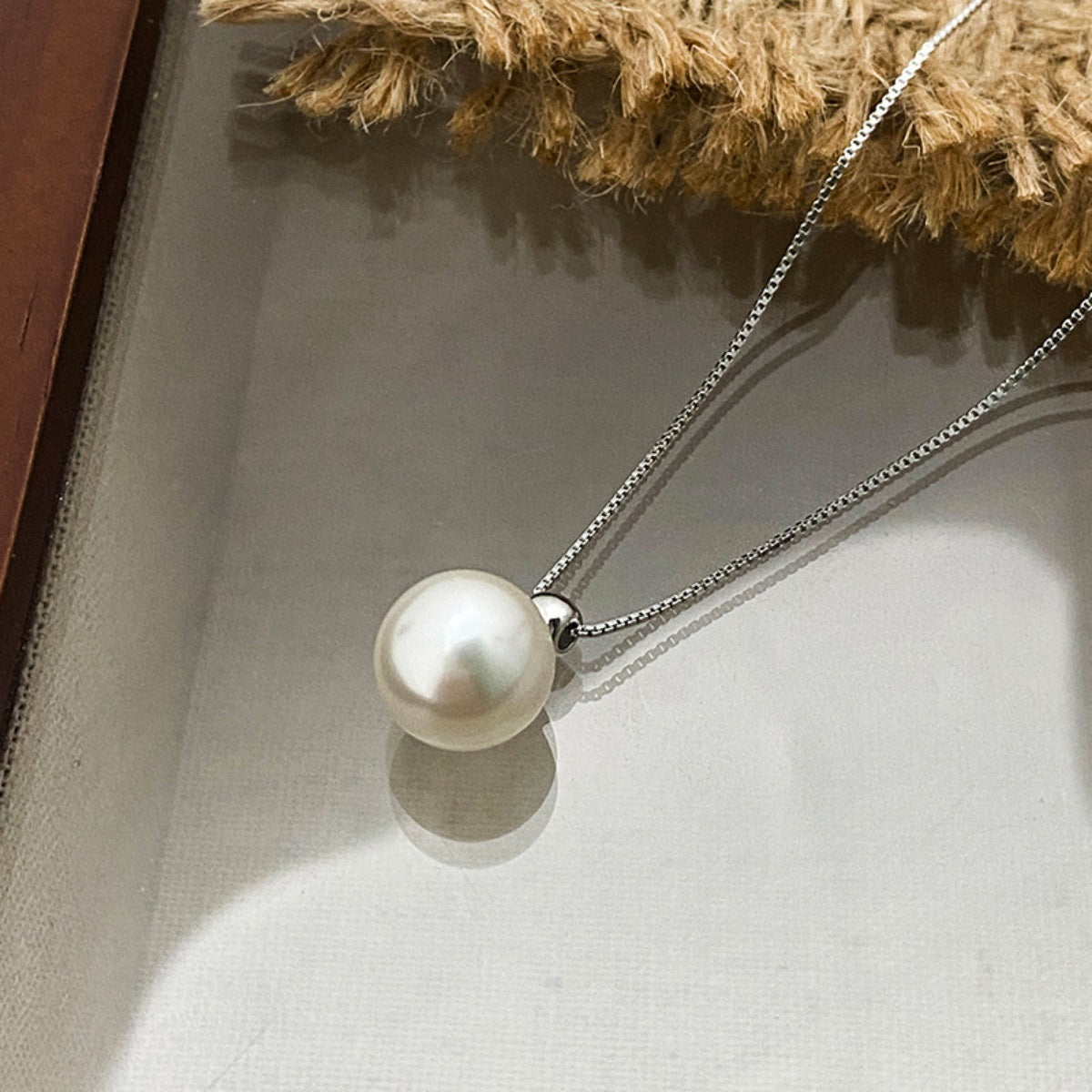 Elegant pearl pendant necklace in silver with a delicate chain.