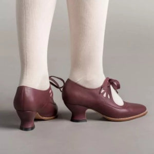 Burgundy leather mary jane shoes with cutouts and bow detail, low heel.