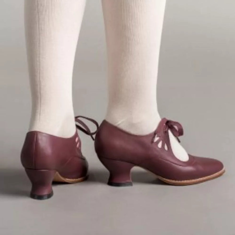 Burgundy leather mary jane shoes with cutouts and bow detail, low heel.
