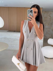 Gray double-breasted mini dress with V-neck, gold buttons, and pleated skirt.