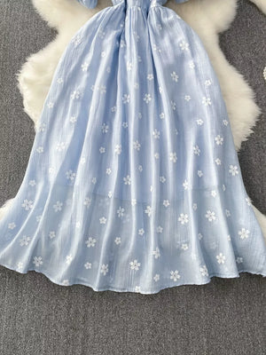 Light blue midi dress with white floral embroidery and puff sleeves.