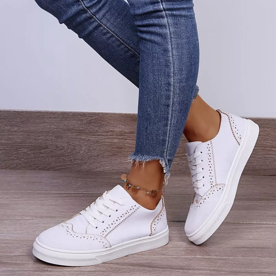 White matte finish lace-up sneakers with perforated detailing and a low sole.