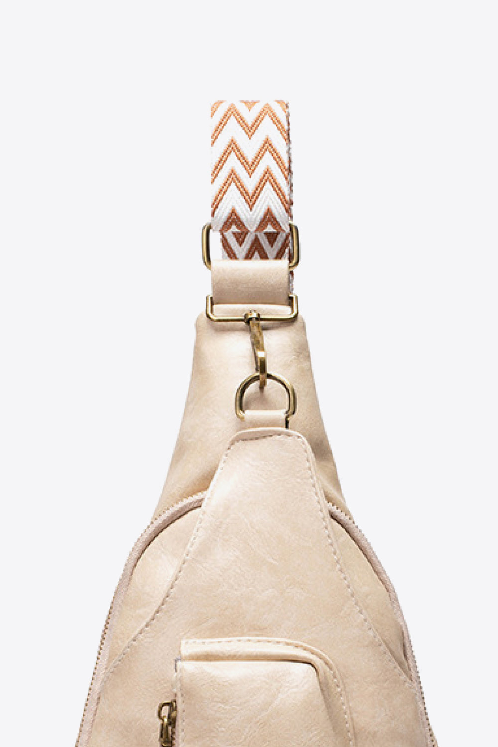 Beige textured sling bag with woven chevron strap and gold hardware detail.