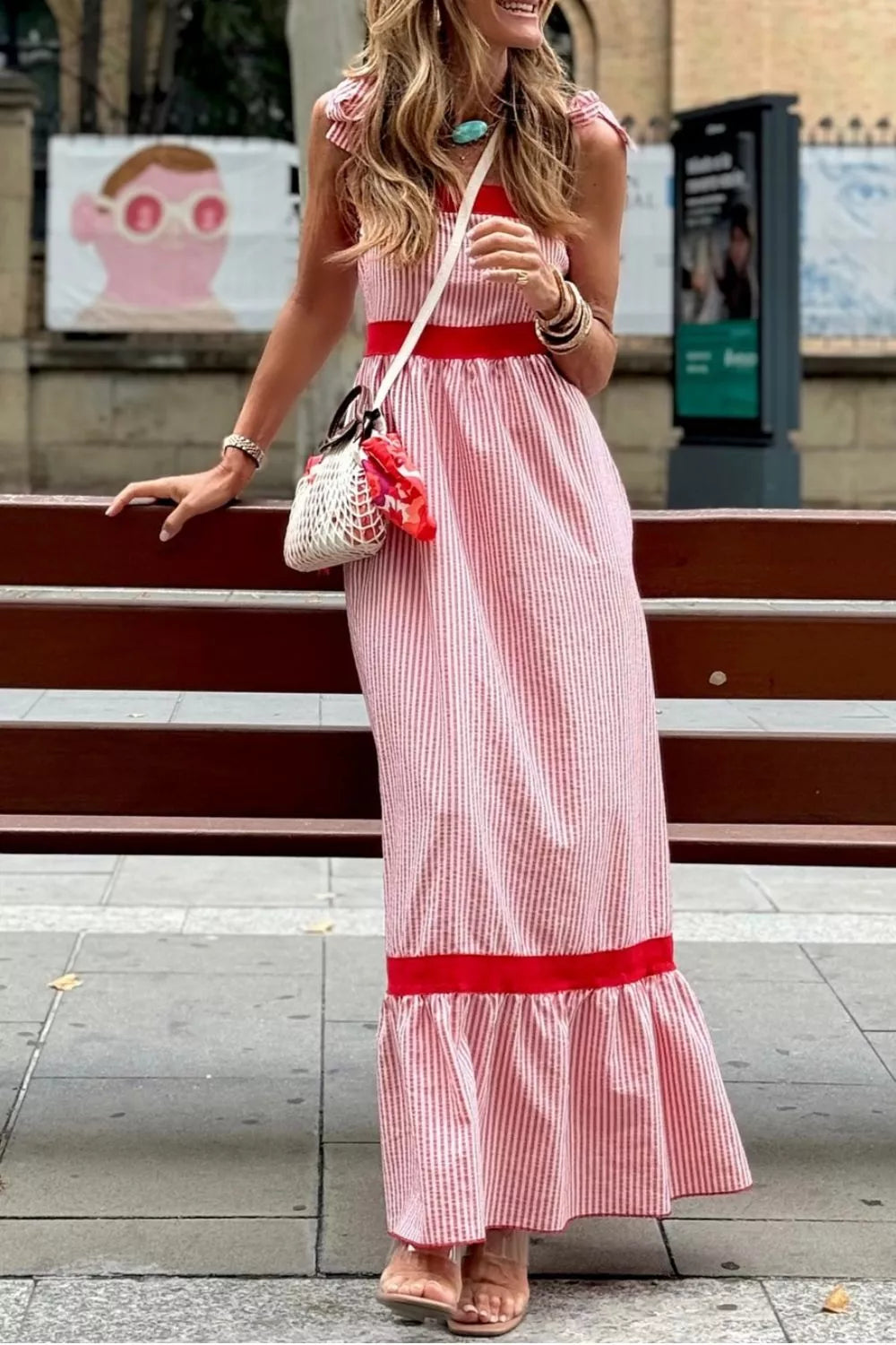 Maxi dress with red and white stripes, bow knot straps, red trim, and ruffled hem.