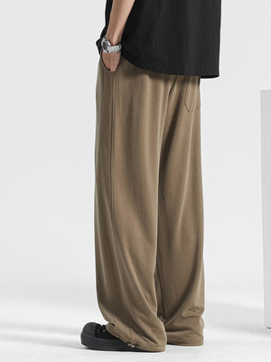 Men's light brown loose fit sweatpants with pockets and a relaxed cut.