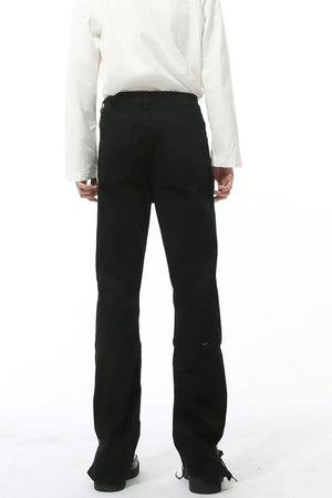 Split-hem black denim jeans with a tailored fit and subtle distressed detail.
