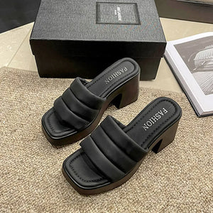 Black padded platform mules with block heel and square toe.