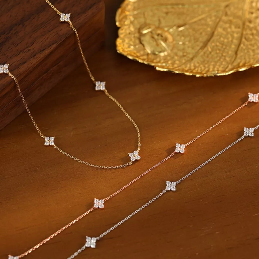 Delicate sterling silver necklace with clover charms in gold, silver, and rose gold.