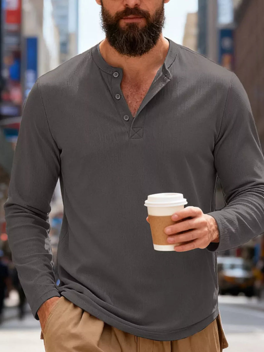 Men's gray long sleeve Henley t-shirt with button placket and textured fabric.