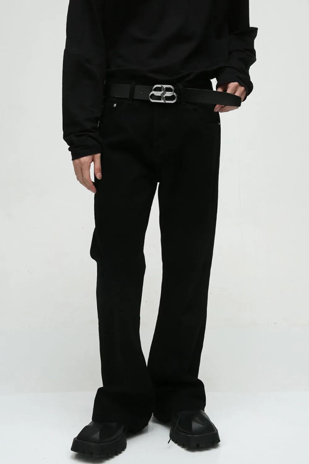 Dark denim bootcut trousers with a classic fit, styled with a black belt.