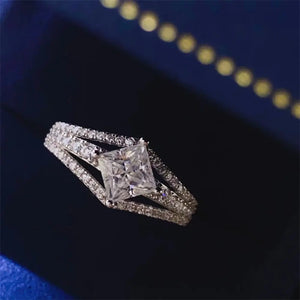 Princess cut moissanite ring in silver with a split shank band and pavé details.