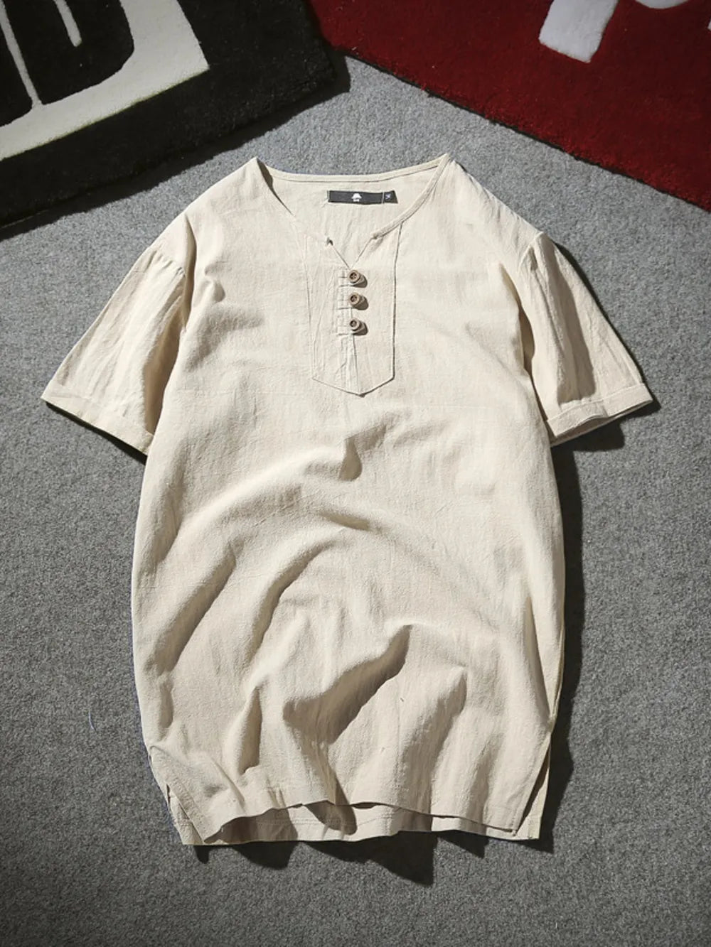 Khaki short sleeve buttoned shirt with V-neck and chest pocket detail.