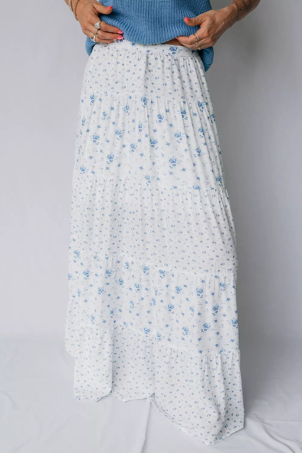 Bohemian tiered maxi skirt with blue floral print on white fabric.