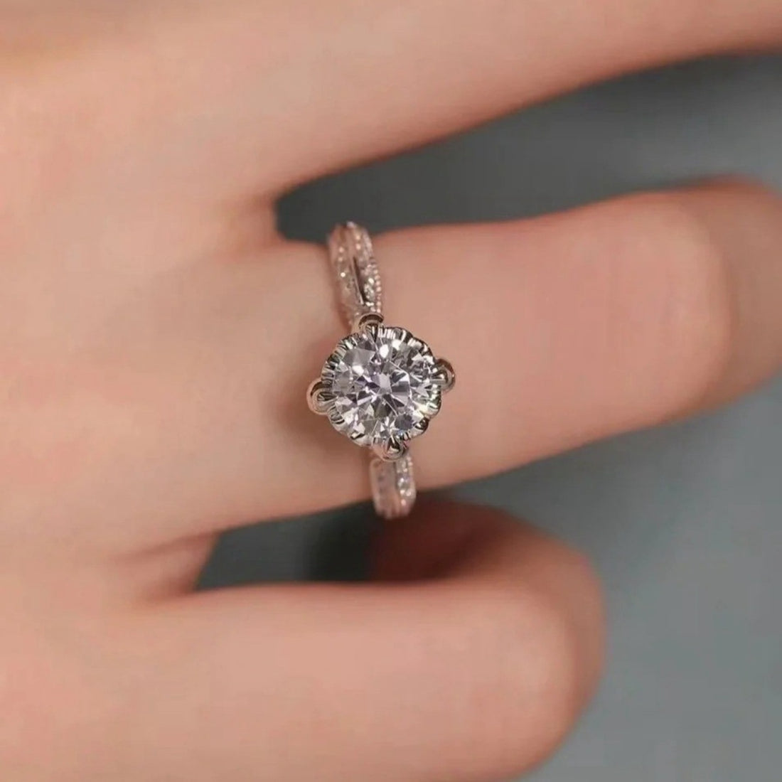 Moissanite sterling silver ring with a round cut center stone and delicate band.