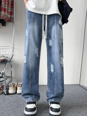 Oversized light blue distressed wide-leg jeans with drawstring and ripped details.