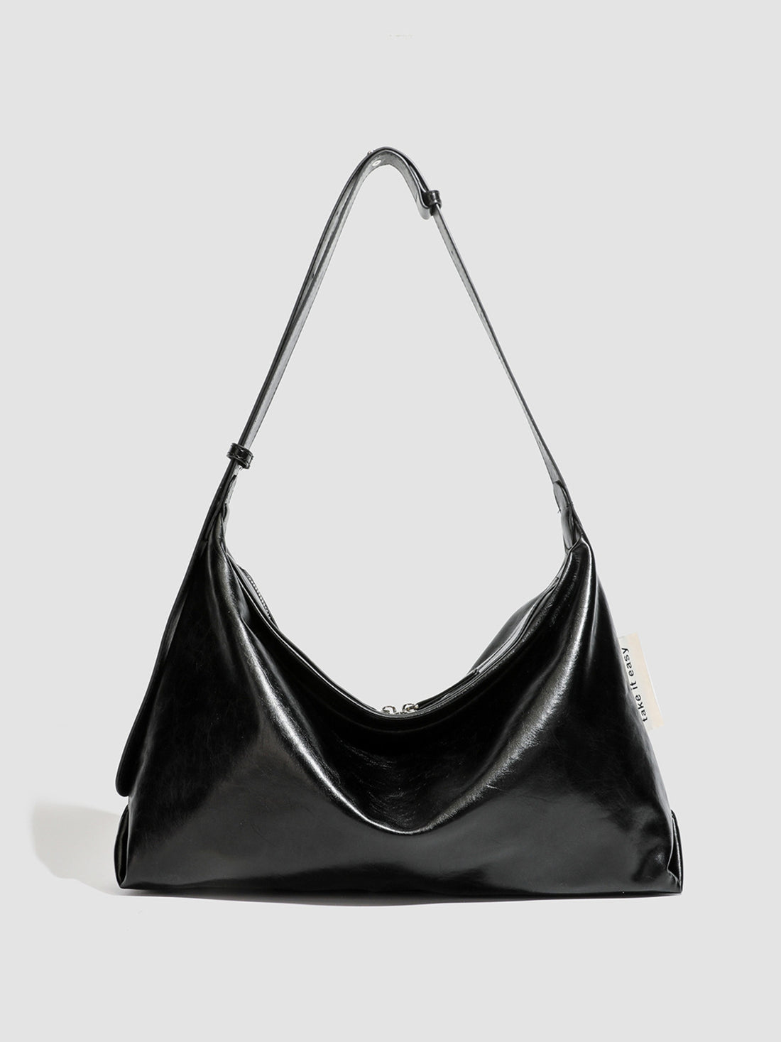 shoulder bag in black featuring glossy finish and slouchy fit