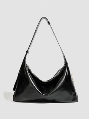 shoulder bag in black featuring glossy finish and slouchy fit