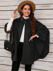 Black cape coat with faux fur trim on collar and cuffs, single button closure.