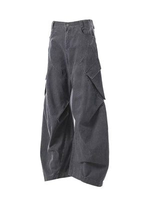 Textured paneled cargo pants in dark gray with baggy fit and multiple pockets.