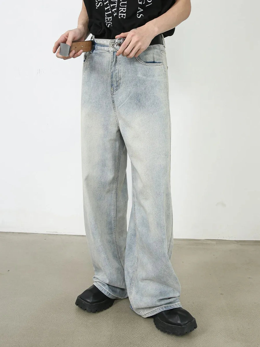Faded denim palazzo pants with a relaxed, oversized fit and light wash.