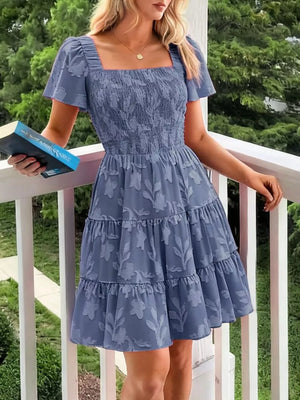Dusty blue smocked mini dress with tiered skirt and floral pattern