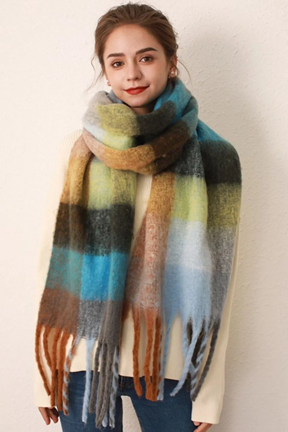 Checked plaid fringed winter wrap scarf in blue/orange grid with fuzzy texture and fringe detail.