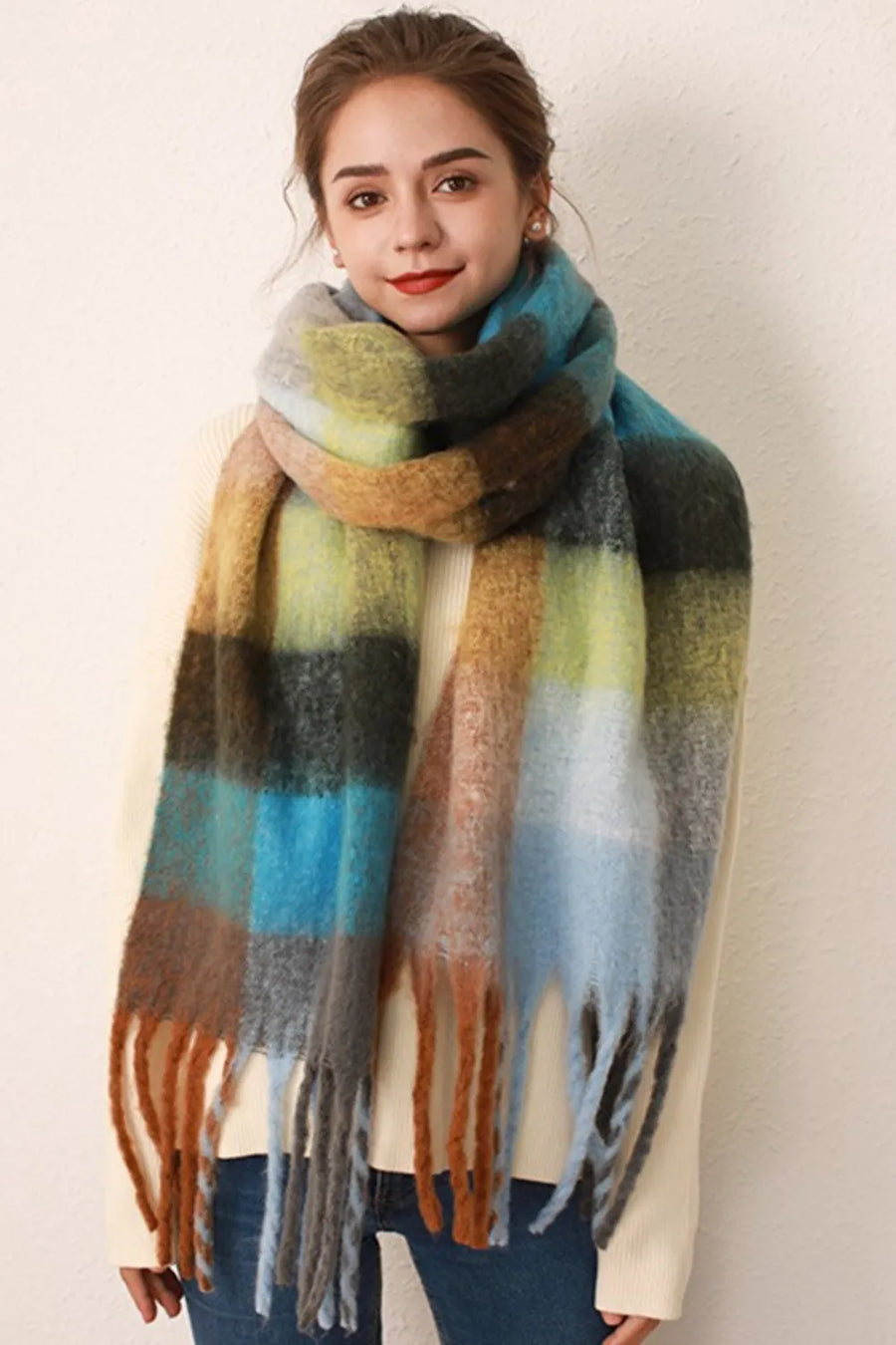 Checked plaid fringed winter wrap scarf in blue/orange grid with fuzzy texture and fringe detail.