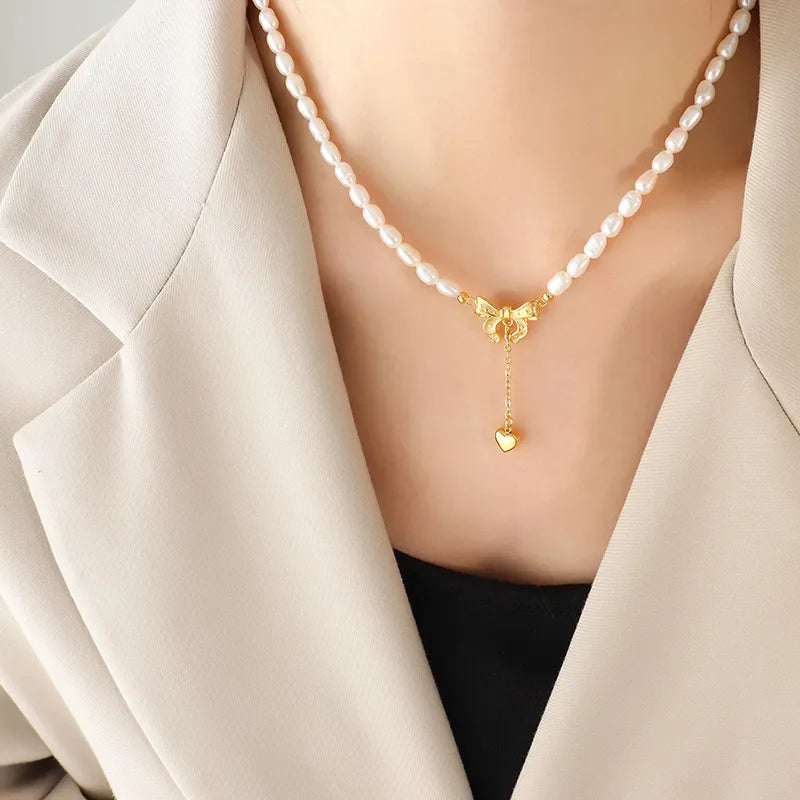 Gold pearl necklace with bow and heart drop pendant
