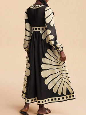 Black and cream geometric print maxi dress with long sleeves and a cinched waist.