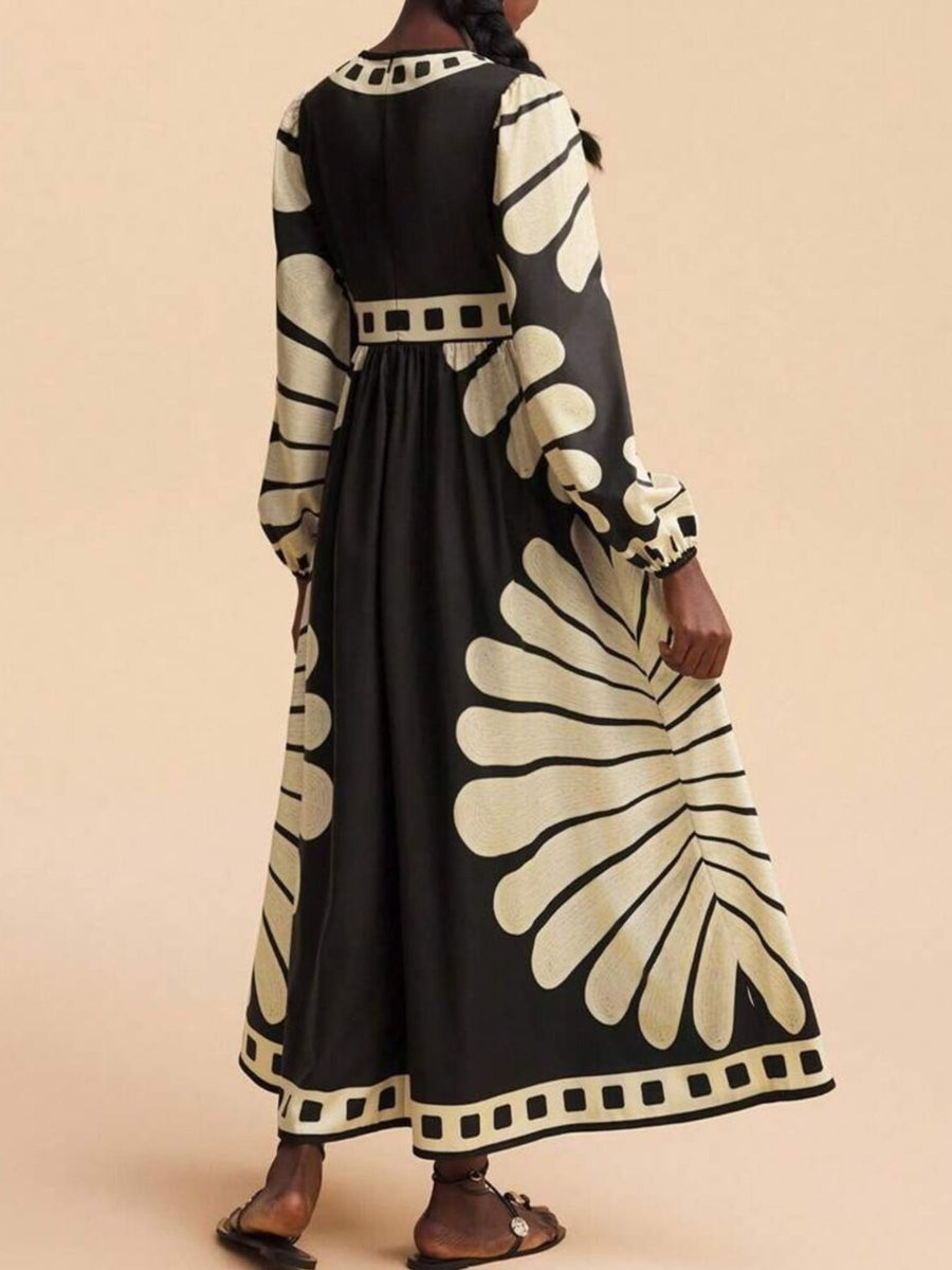 Black and cream geometric print maxi dress with long sleeves and a cinched waist.