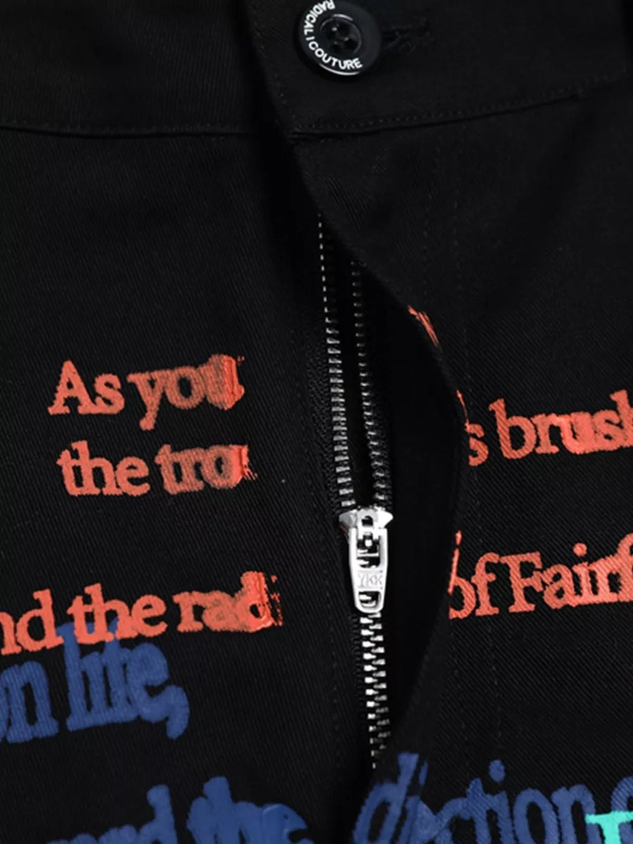 Black cargo pants with vibrant red and blue text print and a silver zipper detail.