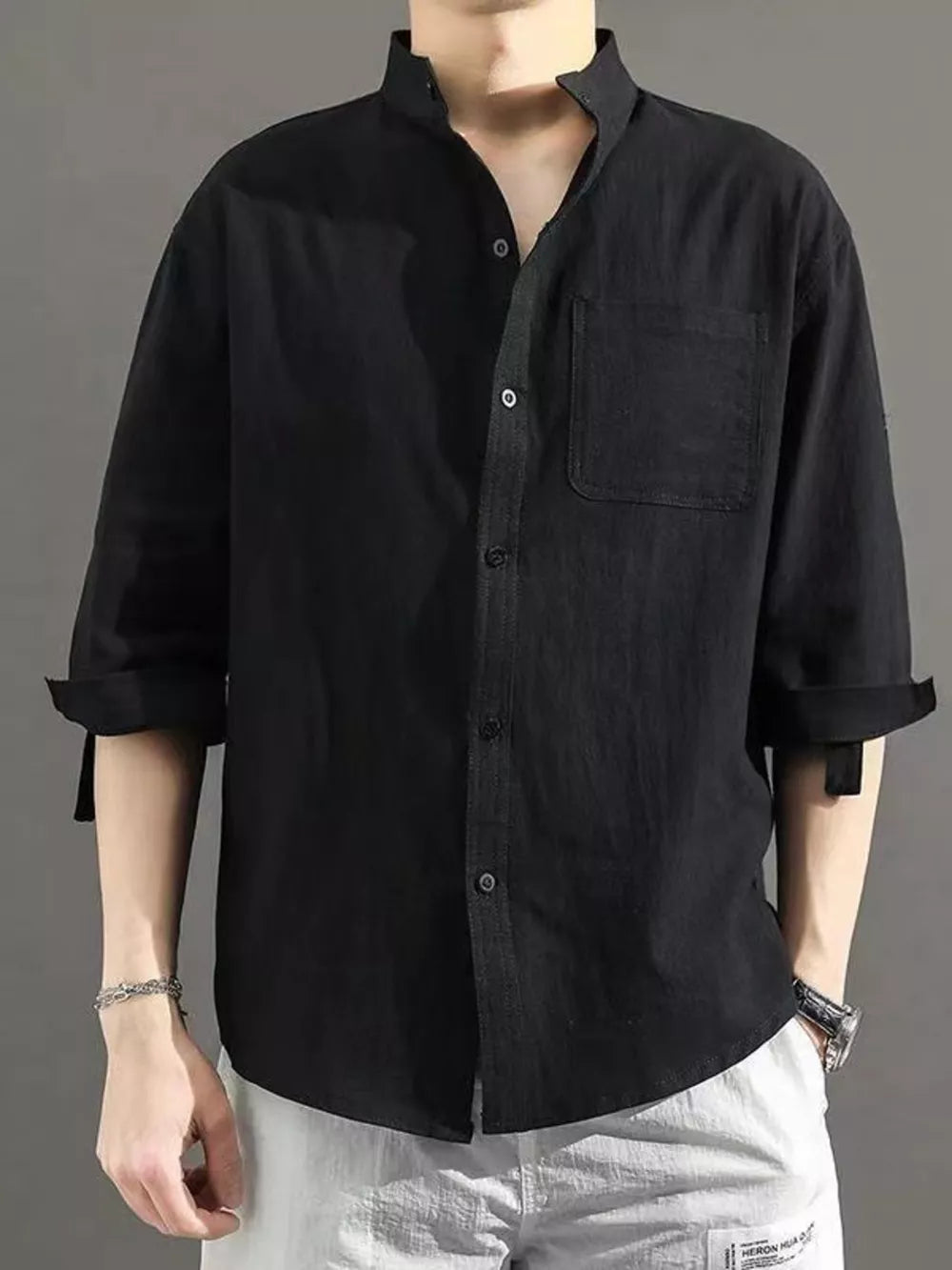Black cotton button-down shirt with roll-up sleeves and chest pocket.
