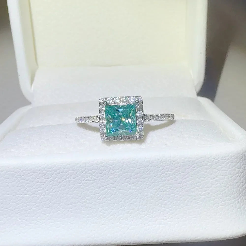 Radiant square halo moissanite ring in silver with a bright blue center stone.