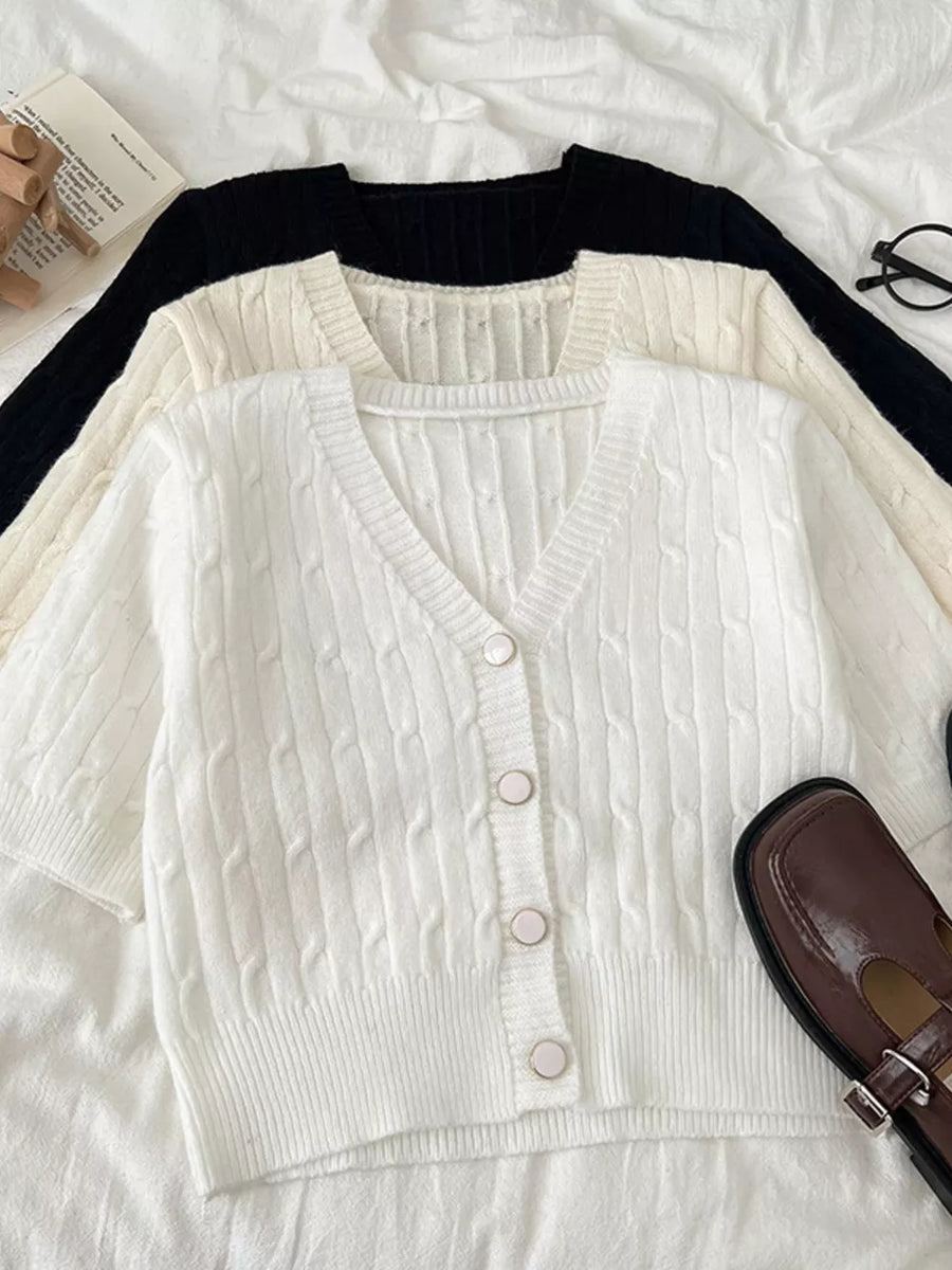 White cable-knit cropped cardigan with V-neck and buttons.