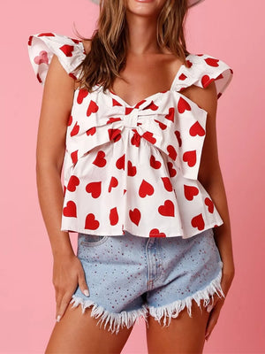 White tank top with red hearts, bow detail, and ruffle trim straps.