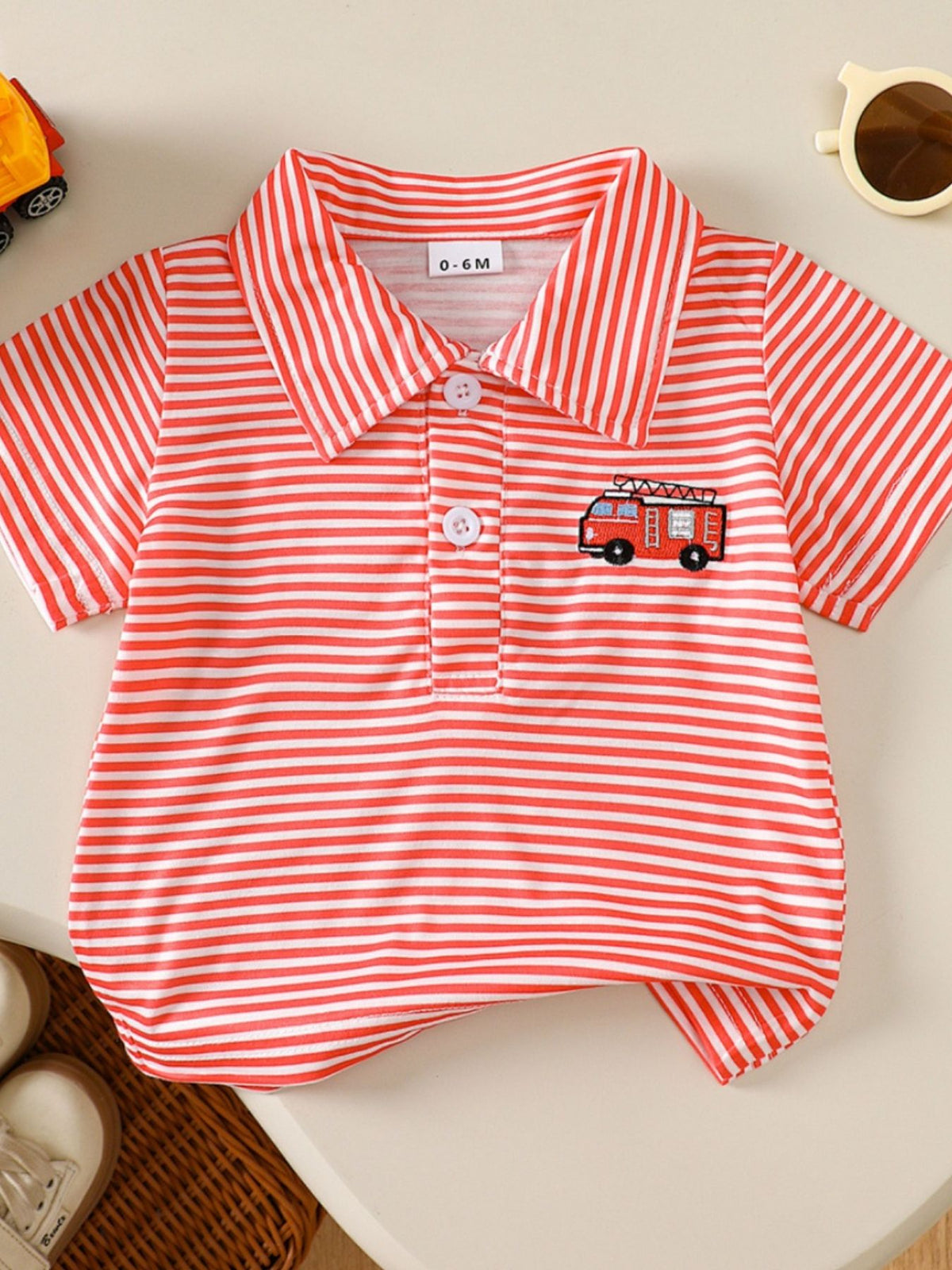 Red and white striped baby polo shirt with embroidered firetruck detail.