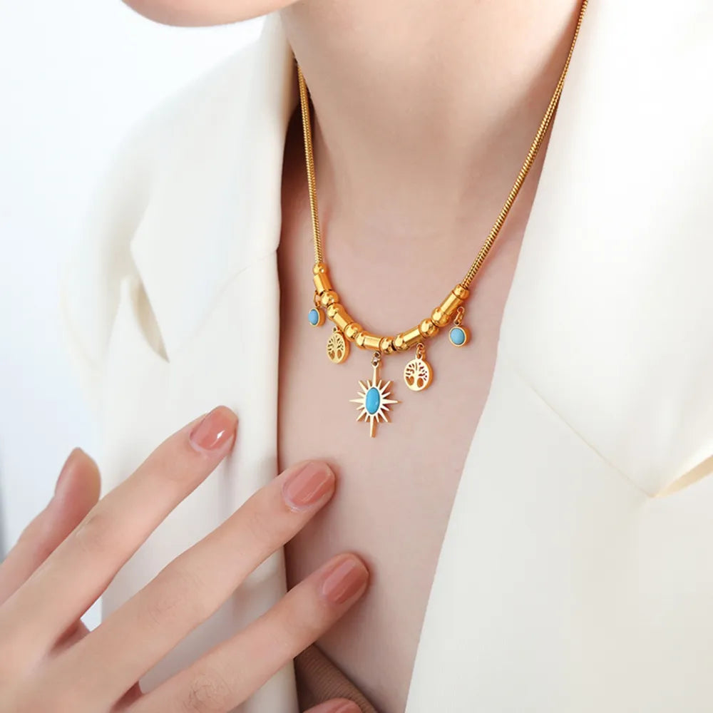 Gold celestial charm pendant necklace with starburst and tree of life charms