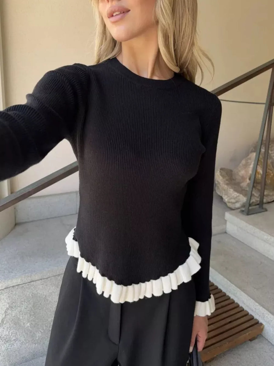 Black ribbed knit sweater with contrast white ruffled hem and cuffs.