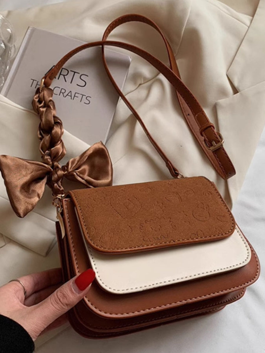Mini two-tone crossbody bag in beige and brown with embossed pattern and braided strap detail.