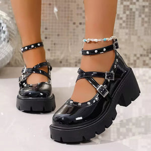 Black patent platform Mary Jane sneakers with studded ankle straps and buckle closures.