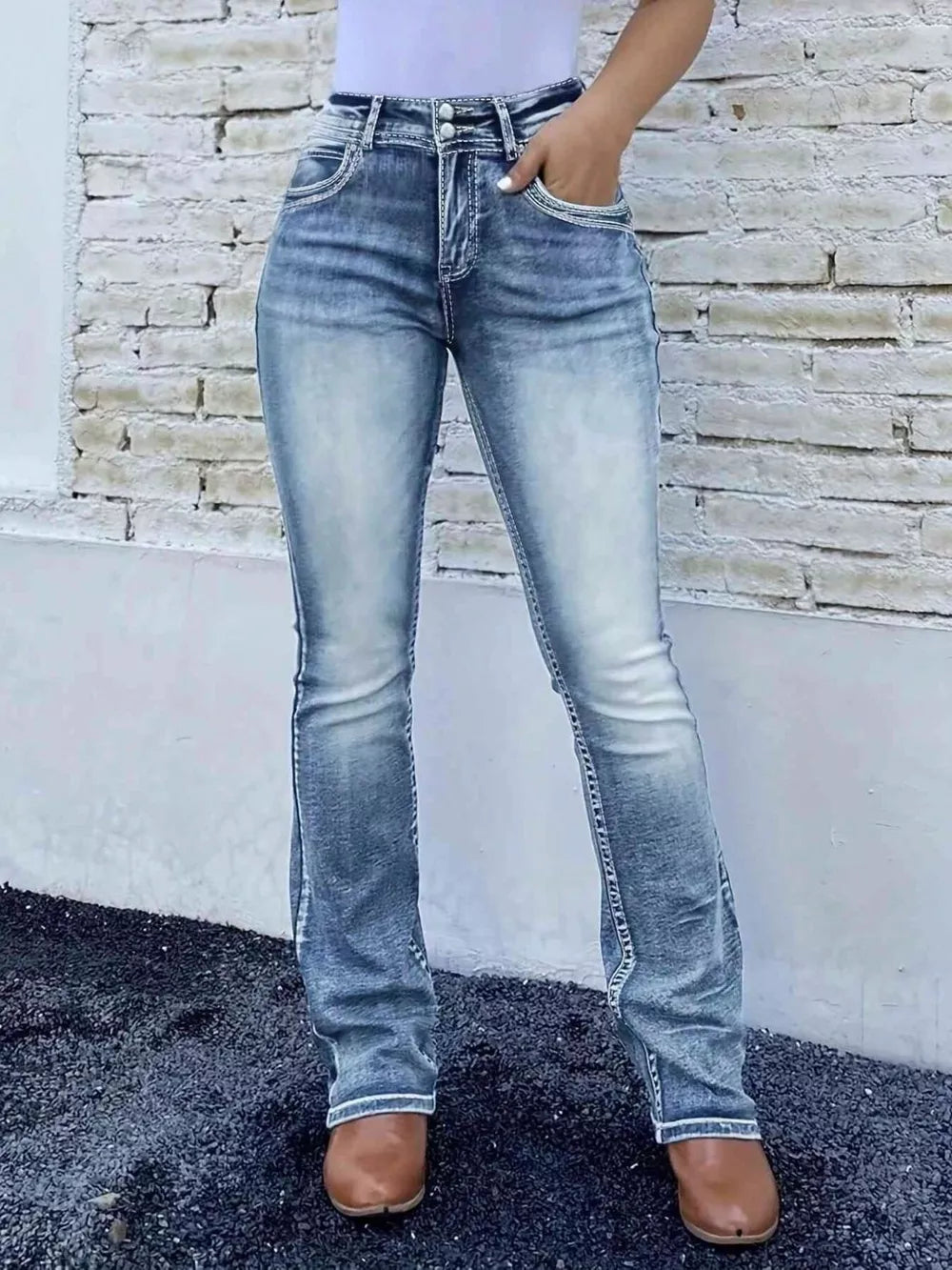 Blue high-waisted bootcut jeans made of cotton with a buttoned closure and faded details.