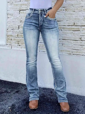 Blue high-waisted bootcut jeans made of cotton with a buttoned closure and faded details.