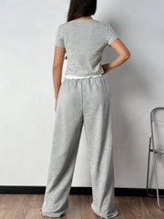 Grey cropped top with lettuce trim and wide-leg sweatpants with drawstring detail.