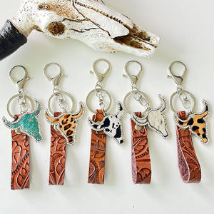 Western leather keychains with bull heads in animal prints and cow spots.