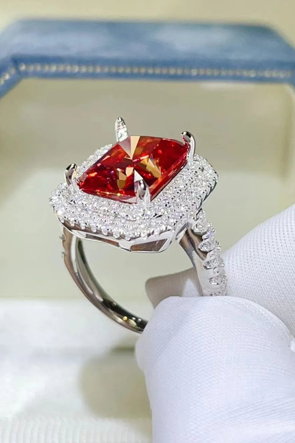 Radiant ruby halo cocktail ring in sterling silver with pave diamond band.